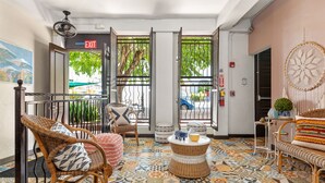 A lobby with wicker furniture, a patterned floor, and an exit sign.
