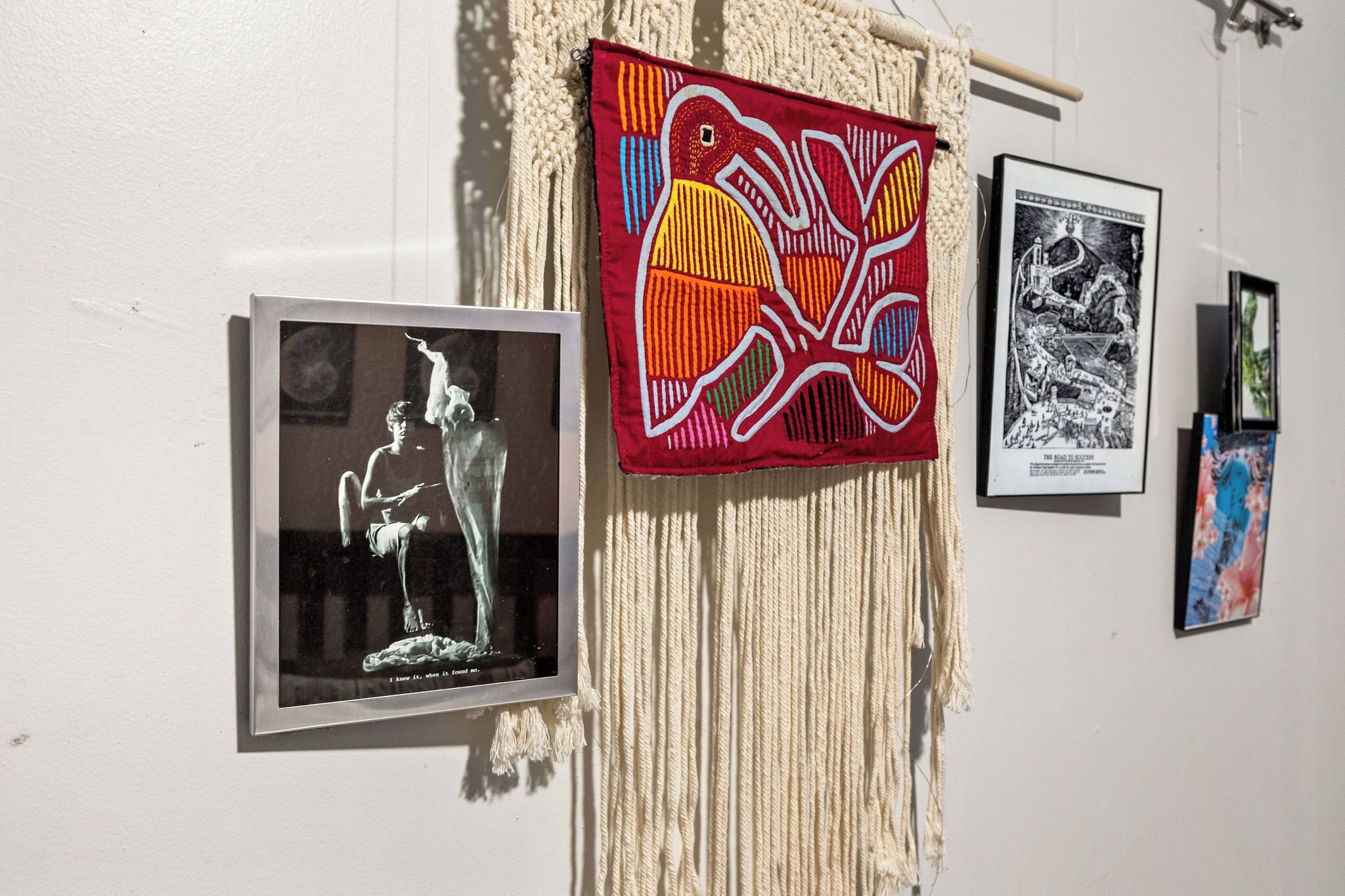A wall with framed artworks, including a bird design and a black and white piece.