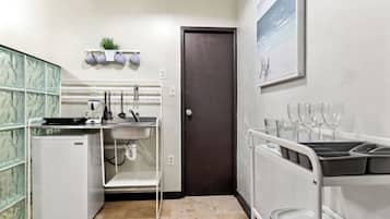 Una cocina compacta con refrigerador, lavamanos y una pequeña encimera.
