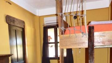 Una habitación con literas, un armario de madera y una puerta.