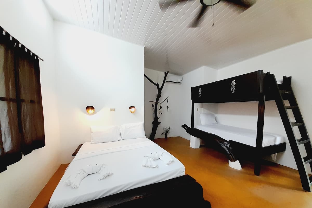 A bedroom with a bed, a wooden bench, and a ladder.