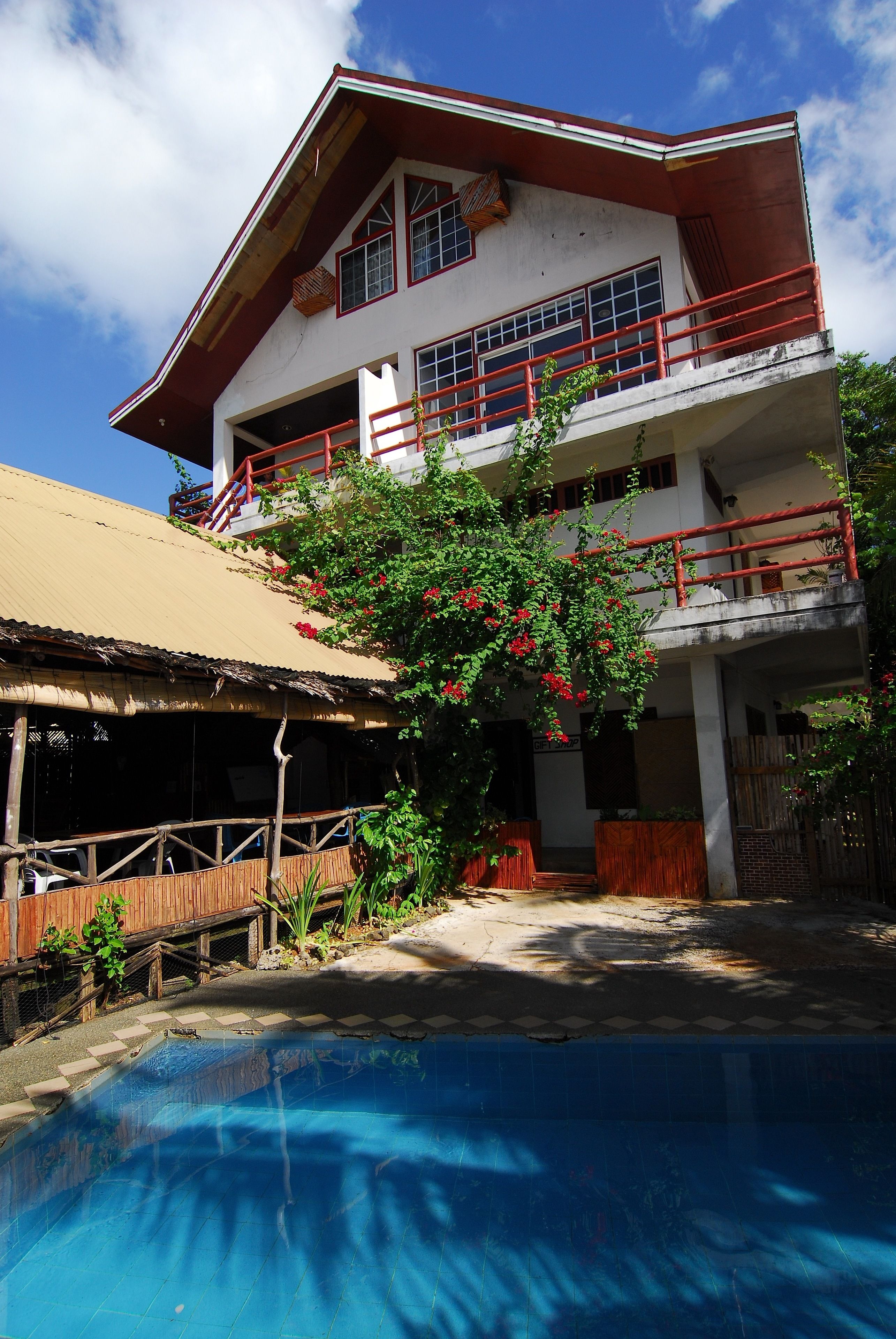 Un bâtiment à deux étages avec une piscine devant.
