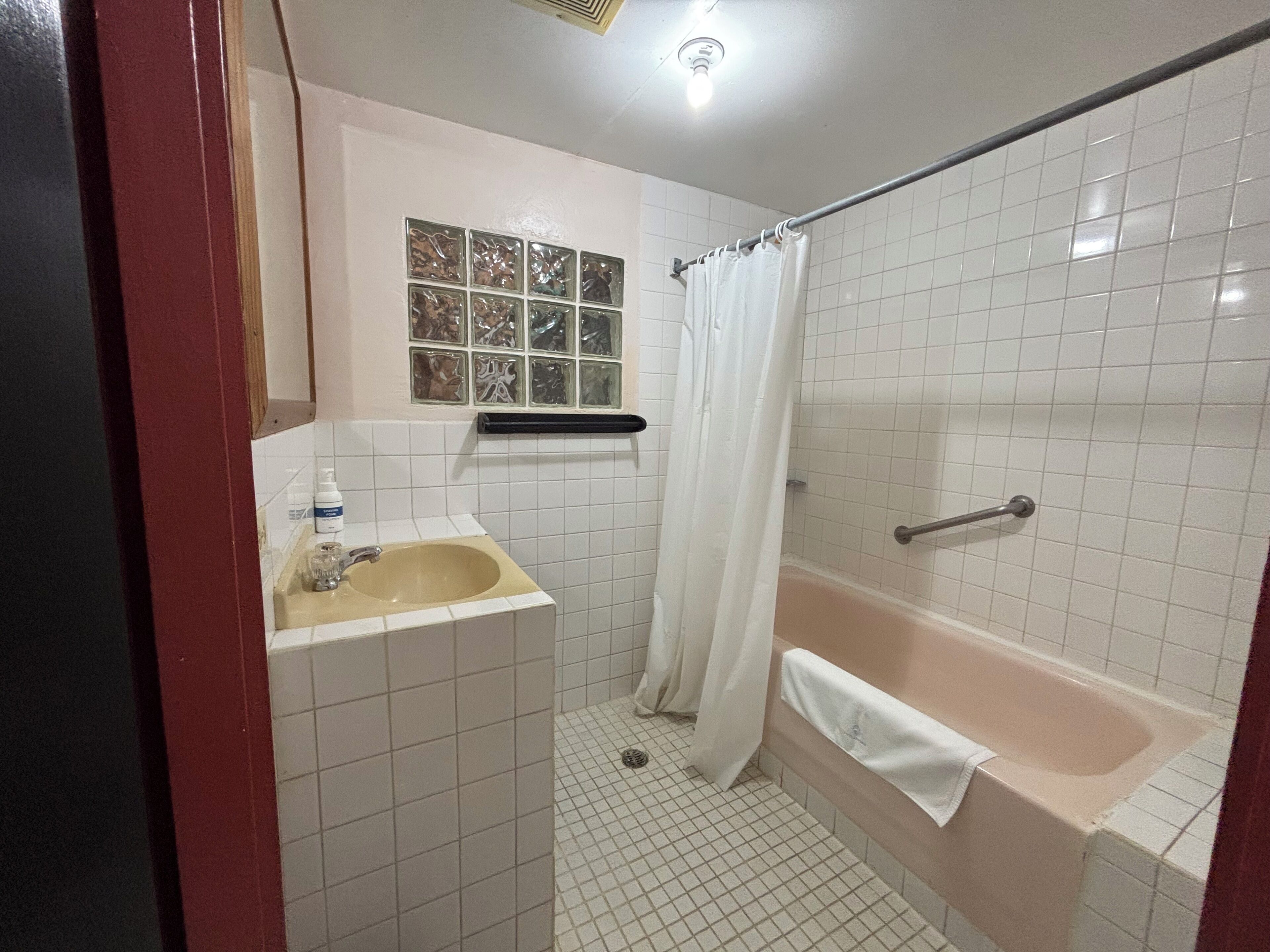 Un baño con lavamanos, bañera y cortina de ducha.