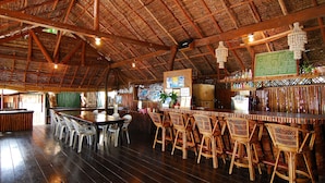 Un amplio bar con mobiliario de madera y techo alto.