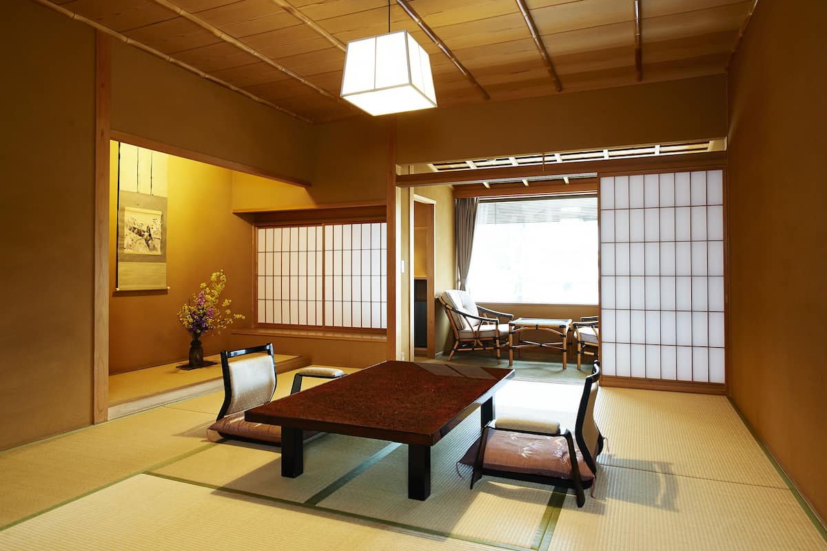Une pièce de style japonais traditionnel, avec un sol recouvert de tatamis, une table basse et des paravents coulissants.