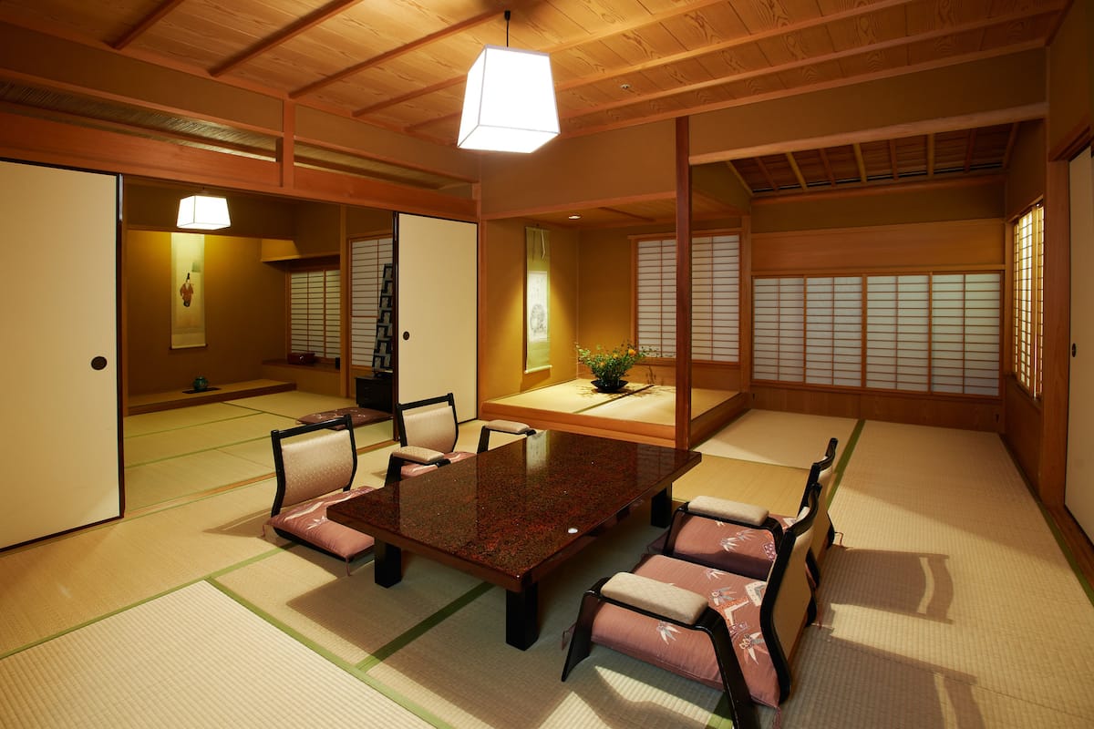 Une pièce de style japonais traditionnel, avec un sol recouvert de tatamis, une table basse et des paravents coulissants.