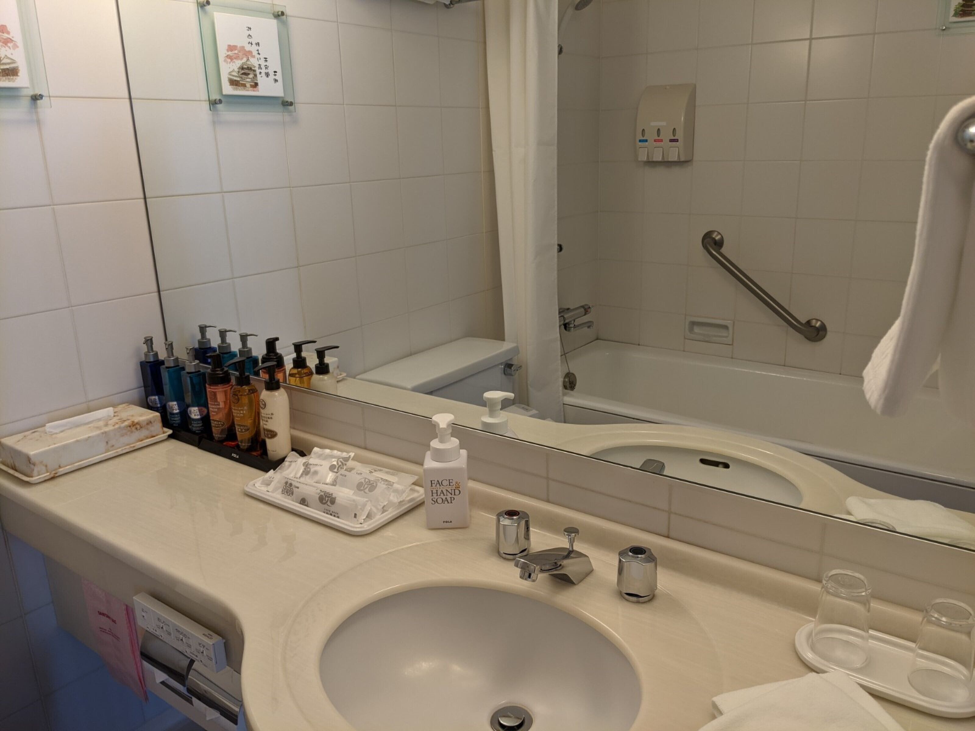 A bathroom with a sink, mirror, and toiletries.