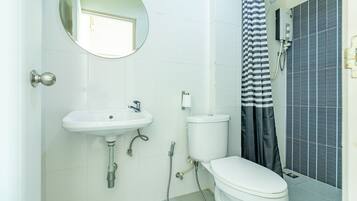 A bathroom with a white sink, toilet, and shower.