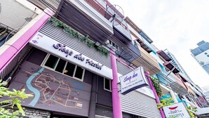 A hostel with a map of the area, a contact number, and a sign indicating the hostel's name. - Sleep Dee Hostel (Bangkok)