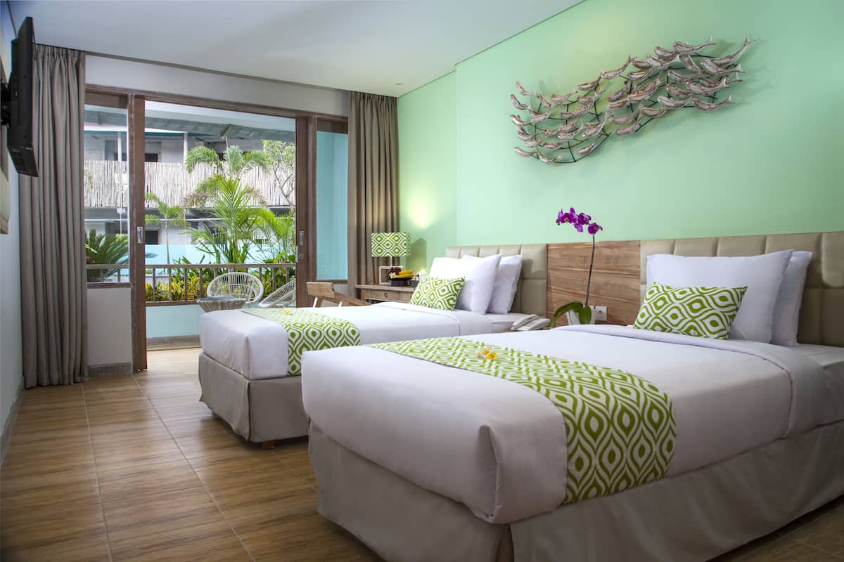 Ein Hotelzimmer mit zwei Betten, einem großen Fenster, einer Wanddekoration und Blick nach draußen.