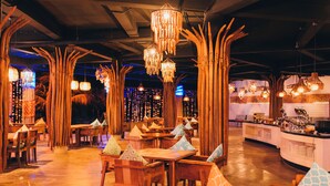 A restaurant interior with wooden furniture, hanging lights, and a counter with various items. - Mahagiri Resort Nusa Lembongan (Lembongan Island)