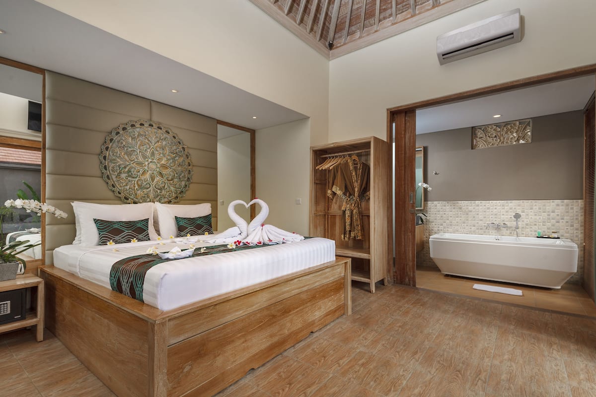 Ein geräumiges Schlafzimmer mit einem großen Bett, einem Holz-Kopfteil und einem eingebauten Kleiderschrank.