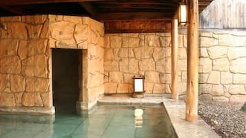 A stone-walled pool area with a door and a lantern.