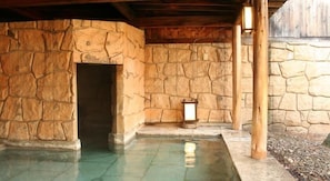 A stone-walled pool area with a door and a lantern.