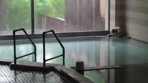 Una piscina interior con una barrera de vidrio y un borde de piedra.