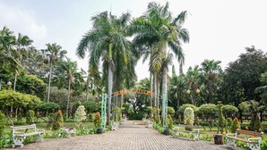 A paved pathway leading to a park entrance with benches and a bicycle. - N Hotel Harmoni Jakarta (Jakarta)