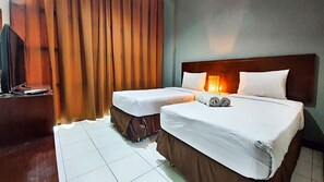 A hotel room with two single beds, a TV, and a curtain. - N1 Hotel Tanah Abang (Jakarta)