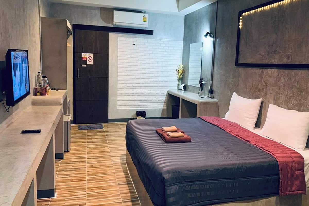 A modern hotel room with a bed, bedside table, and a TV.