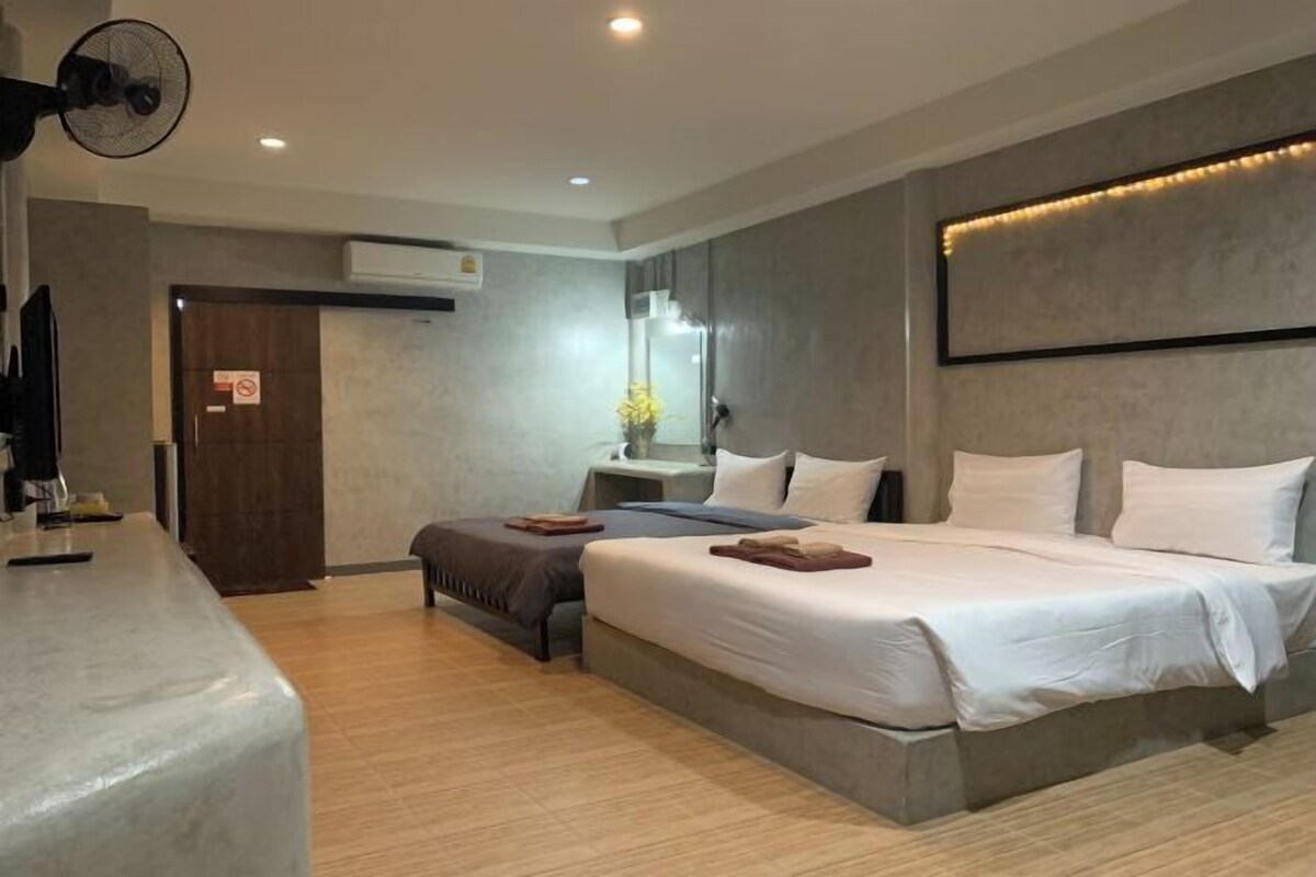 A modern hotel room with a large bed, a desk, and a mirror.