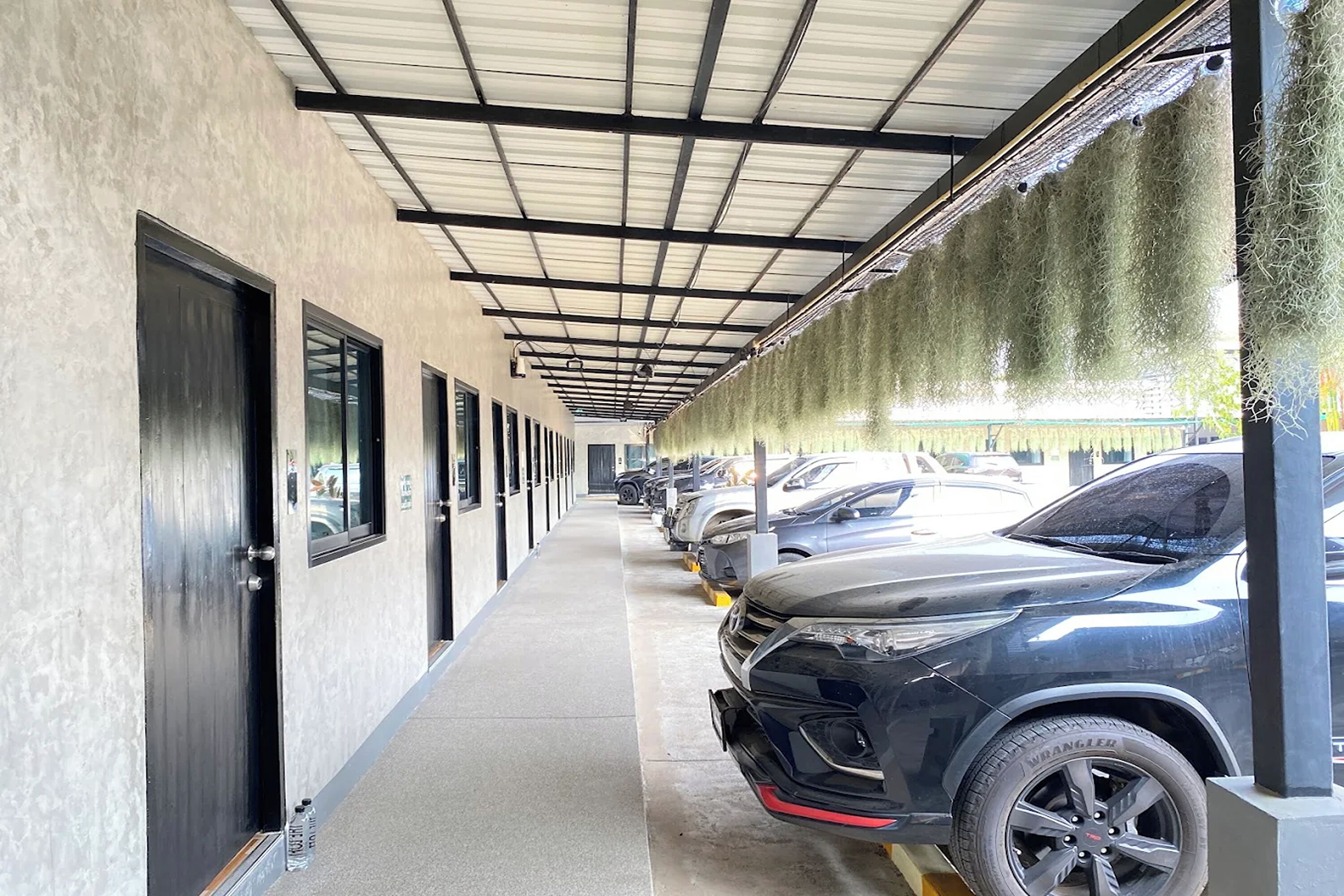 A covered parking area with cars parked along the side.