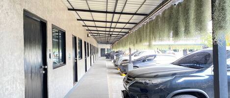 A covered parking area with cars parked along the side.