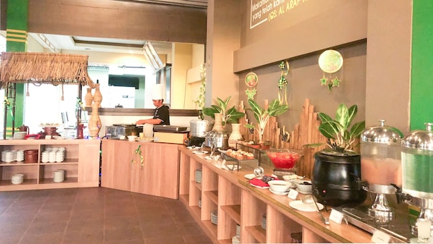 A buffet setup with various food items and a chef preparing food. - Grand Madani Hotel (Mataram)