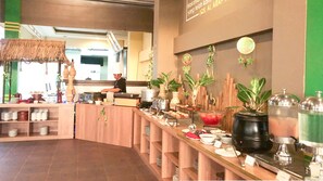 A buffet setup with various food items and a chef preparing food. - Grand Madani Hotel (Mataram)