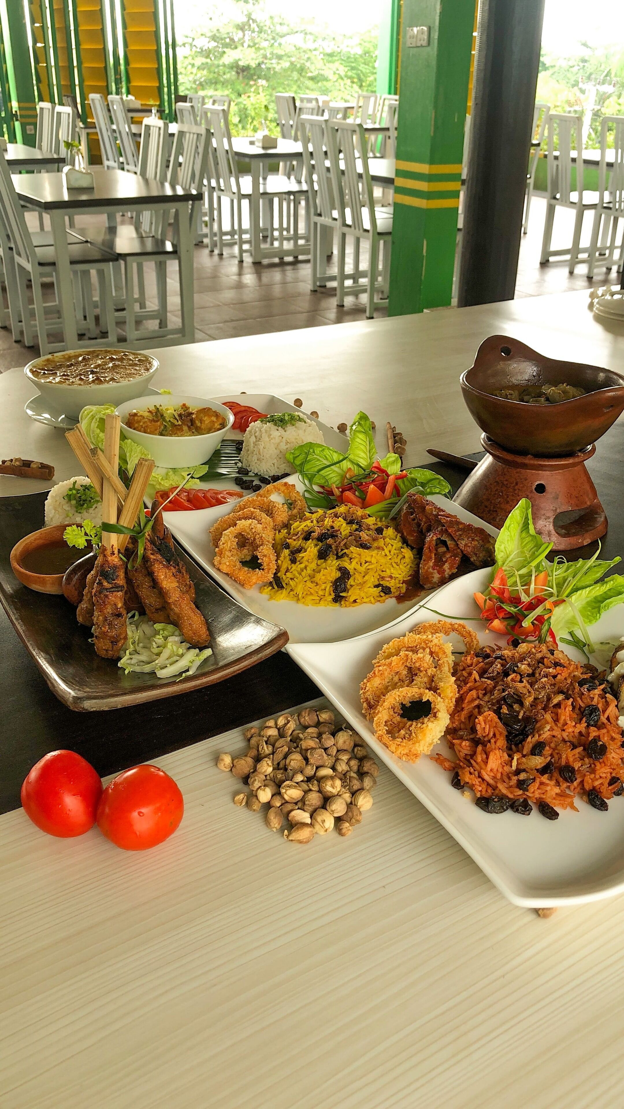 A dining table with various dishes including rice, meat, and vegetables.
