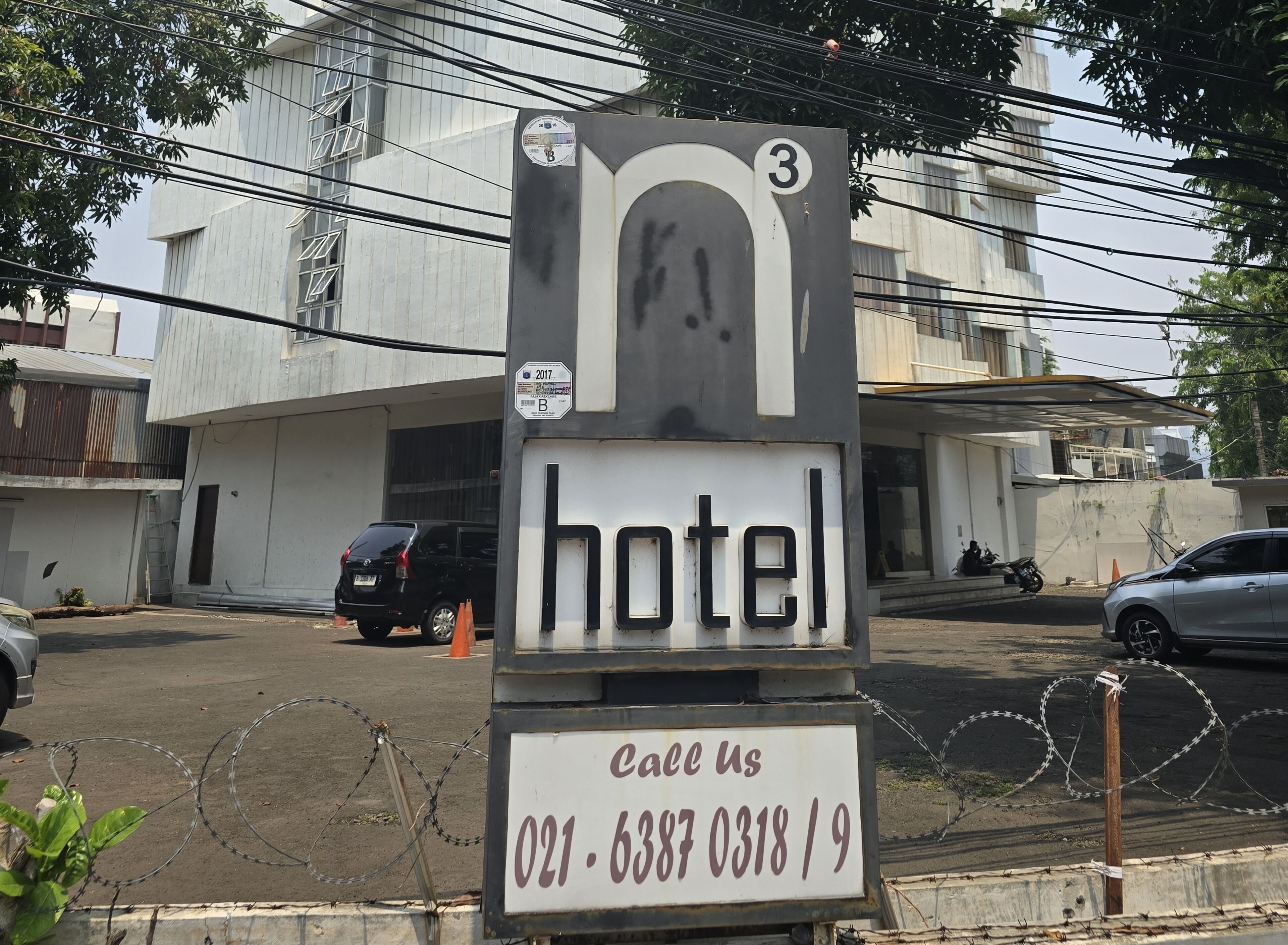 A hotel sign with a contact number.