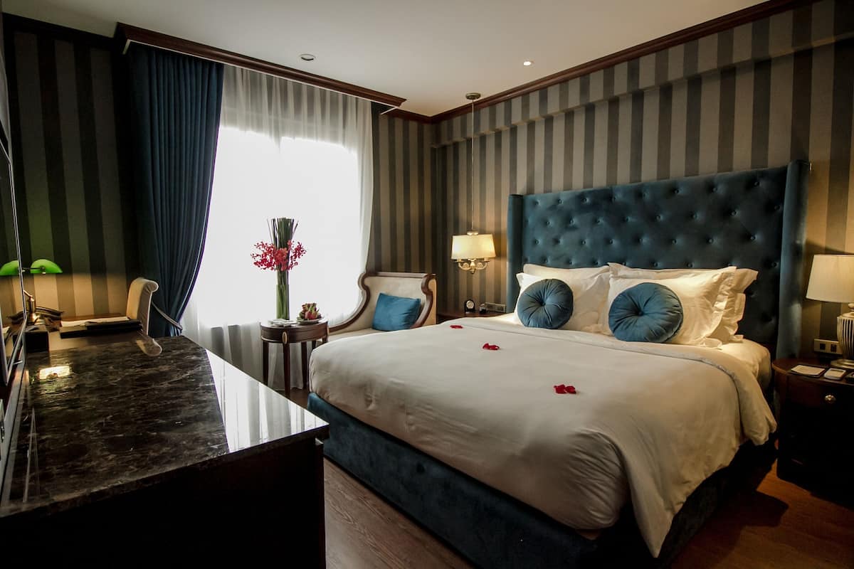 Une chambre d’hôtel avec un grand lit, un bureau et une chaise.