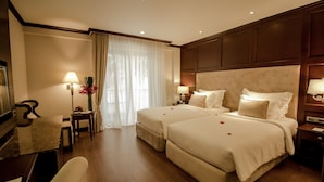 Una habitación de hotel con dos camas, un escritorio, una silla y un televisor.