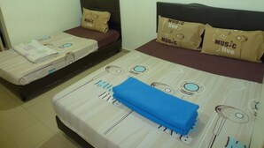 Une chambre d’hôtel avec deux lits simples, chacun doté d’une tête de lit et d’un oreiller orné du texte « MUSIC live ».