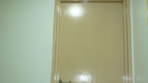 Une porte fermée, avec un panneau vert indiquant la sortie de secours au-dessus.