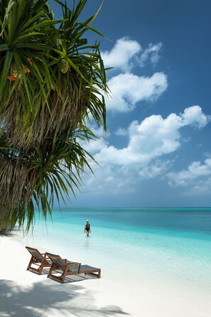 On the beach, white sand, sun-loungers, beach umbrellas