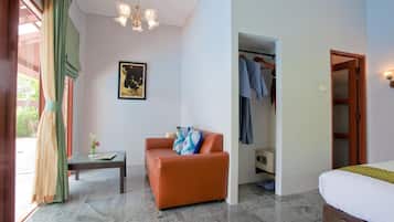 A hotel room with a bed, a sofa, a table, a wardrobe, and a chandelier.