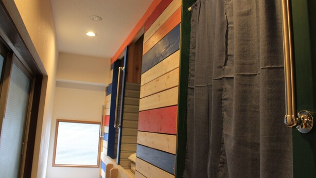 Un pasillo con paneles de madera y una ventana con persianas.