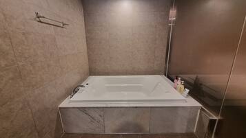 Deluxe Room | Bathroom | Combined shower/tub, deep soaking tub, designer toiletries, hair dryer