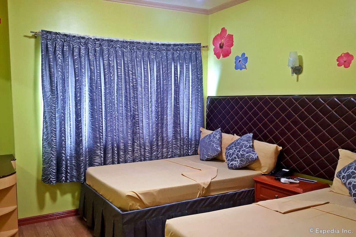 A room with a bed, a bedside table, a small desk, and a wall-mounted TV.