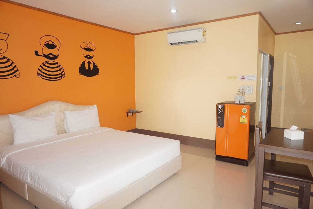 Une chambre d’hôtel équipée d’un lit, d’un bureau, d’un climatiseur et d’un réfrigérateur.