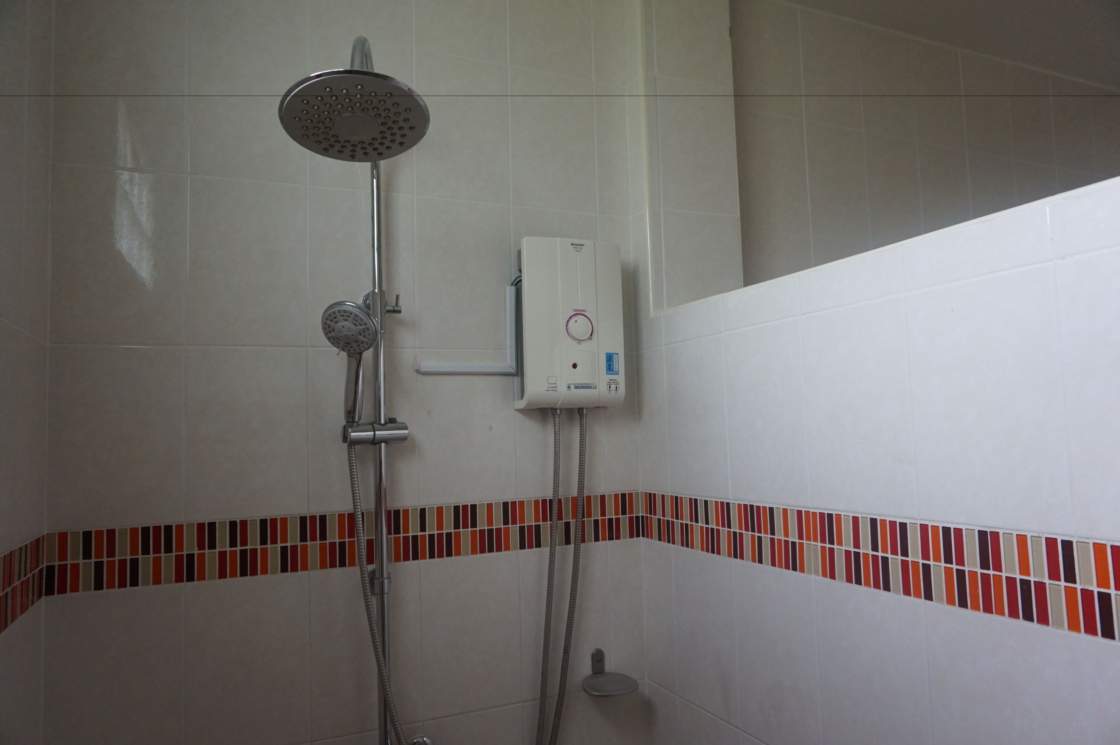 Eine Dusche mit Handbrause und einer fest installierten Bedienblende.