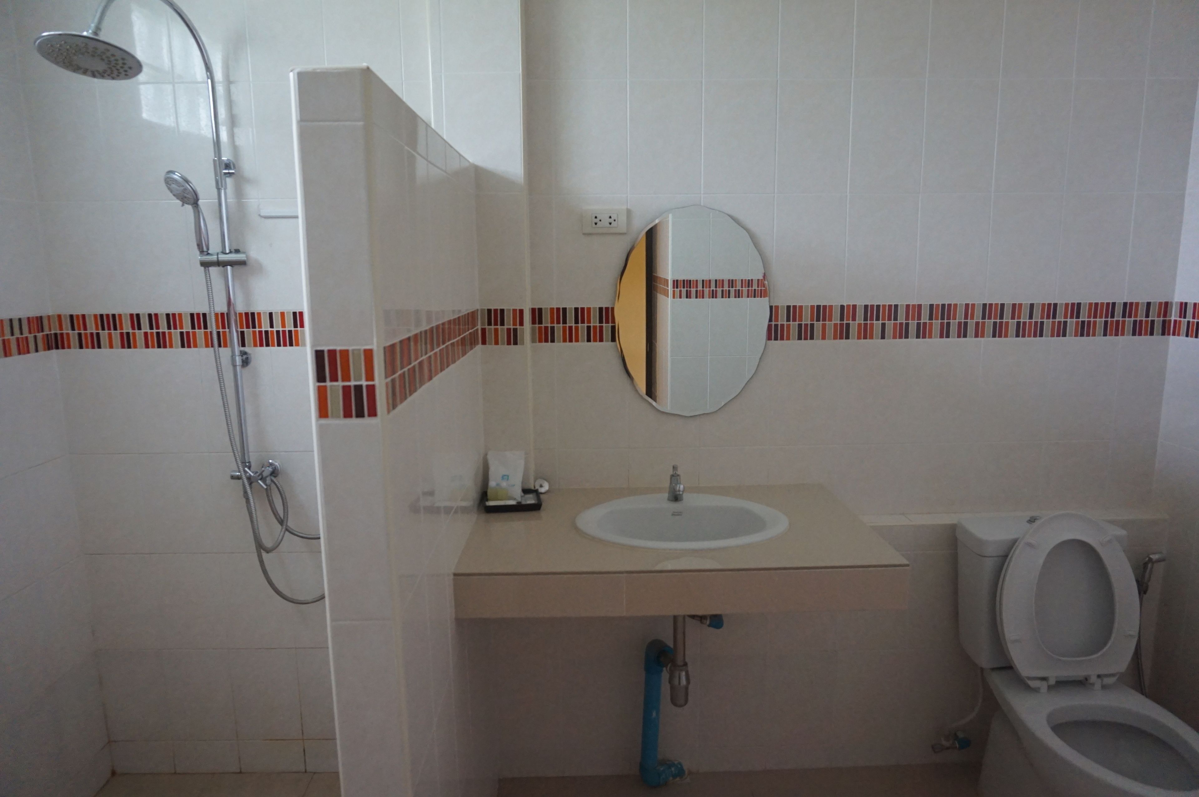 A bathroom with a shower, sink, and toilet.