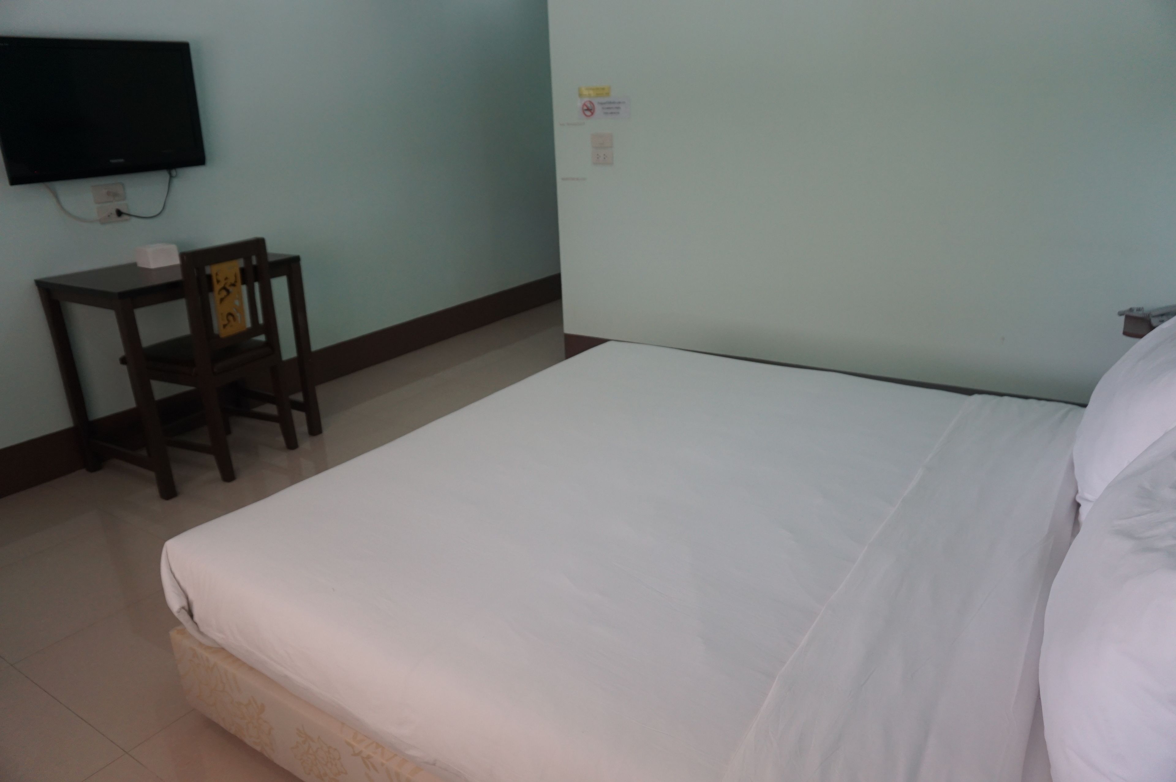 Una habitación de hotel con una cama, un escritorio y una silla.
