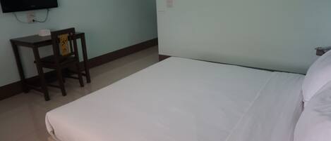 Una habitación de hotel con una cama, un escritorio y una silla.