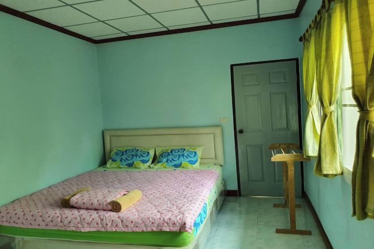 Een slaapkamer met een bed, een deur en een stoel.
