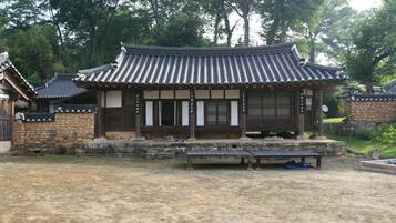 Een traditioneel Koreaans paviljoen met een pannendak, houten balken en stenen muren.