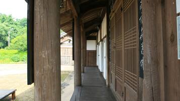 Een houten gang met traditionele Japanse deuren en een bankje erbuiten.