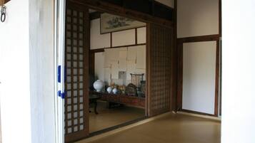 A traditional Japanese room with tatami flooring, a shoji screen door, and a low wooden table with ceramics.