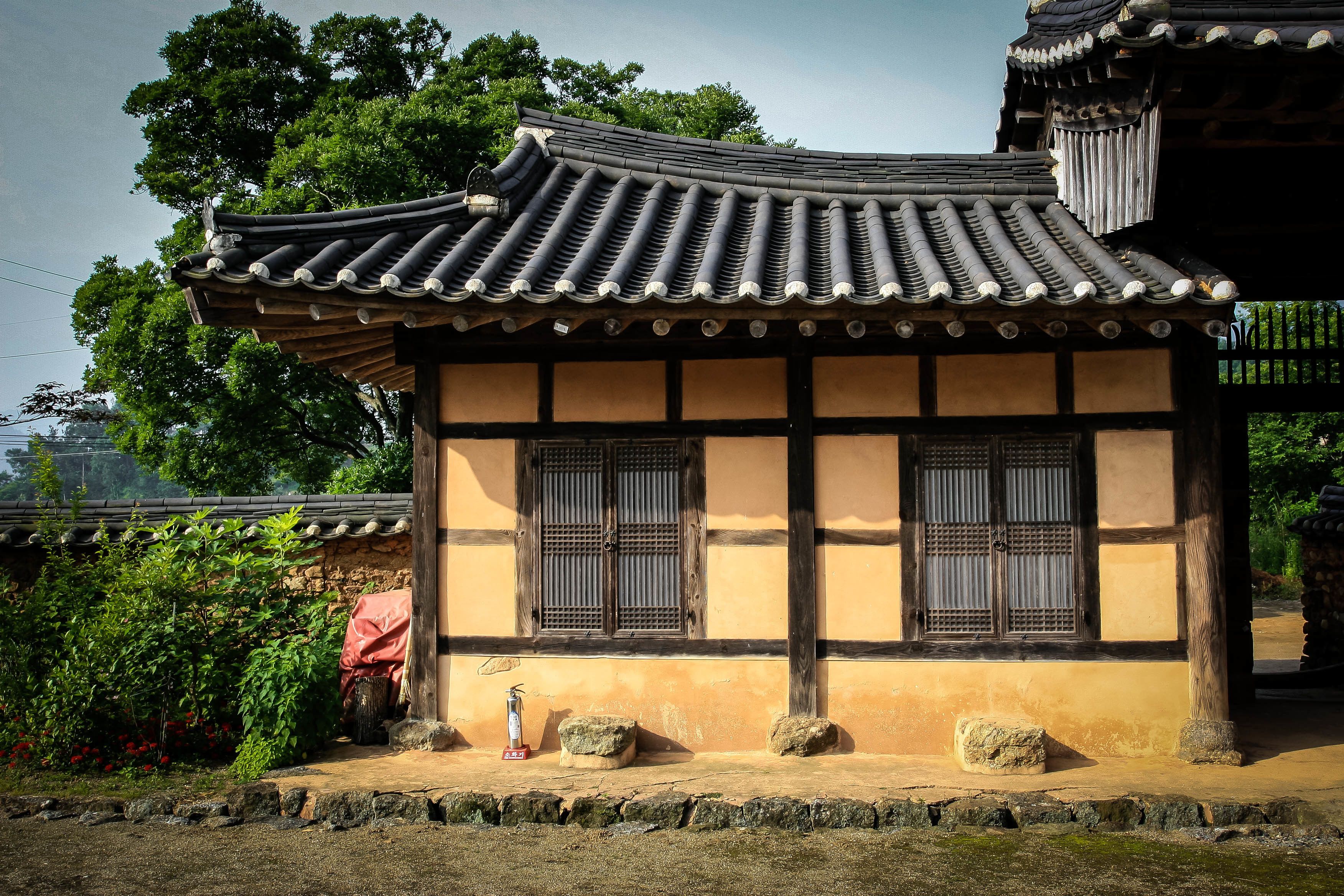 A traditional building with a tiled roof, wooden beams, and a stone base.