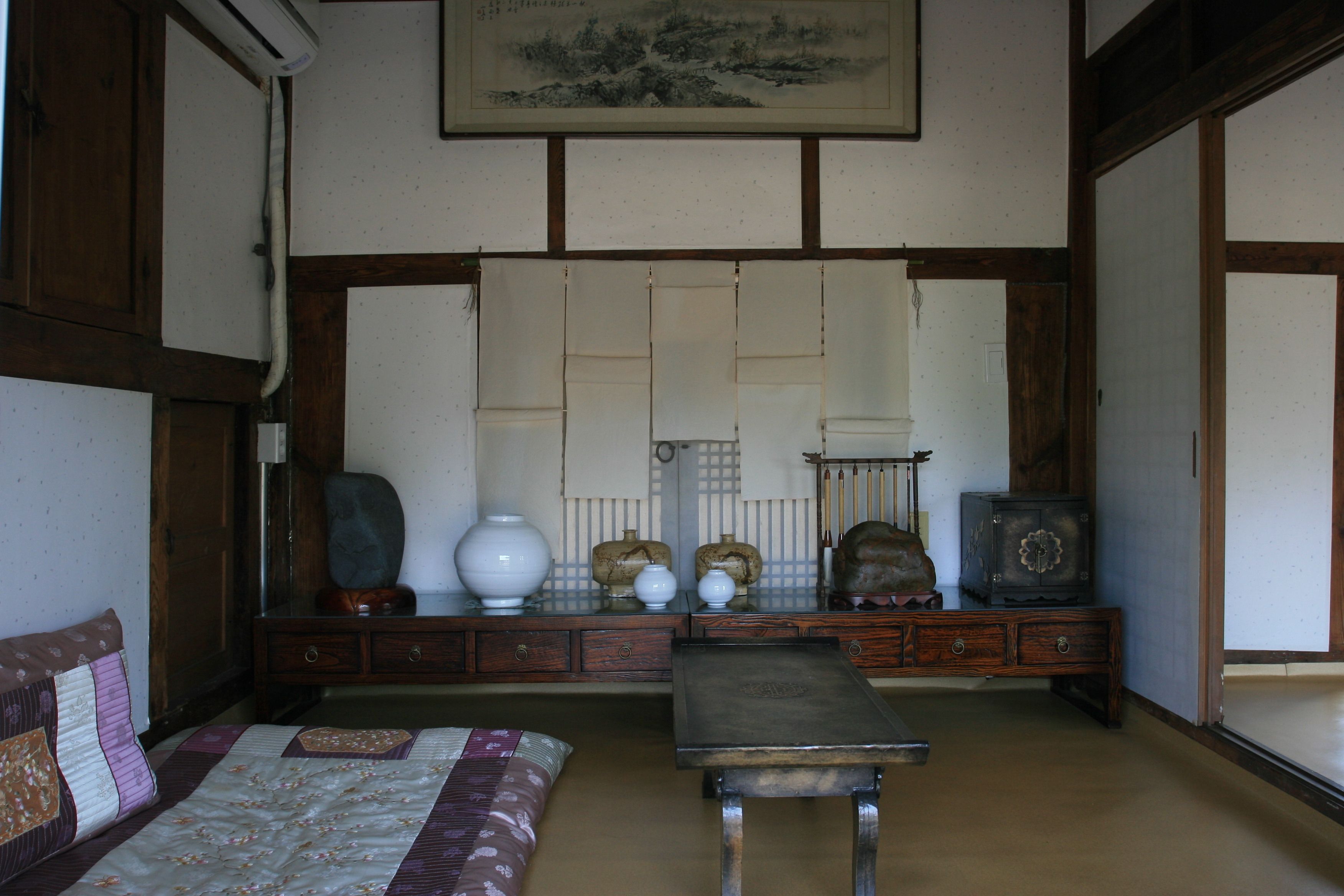 A traditional Japanese room with tatami flooring, a low wooden table, and a sofa.