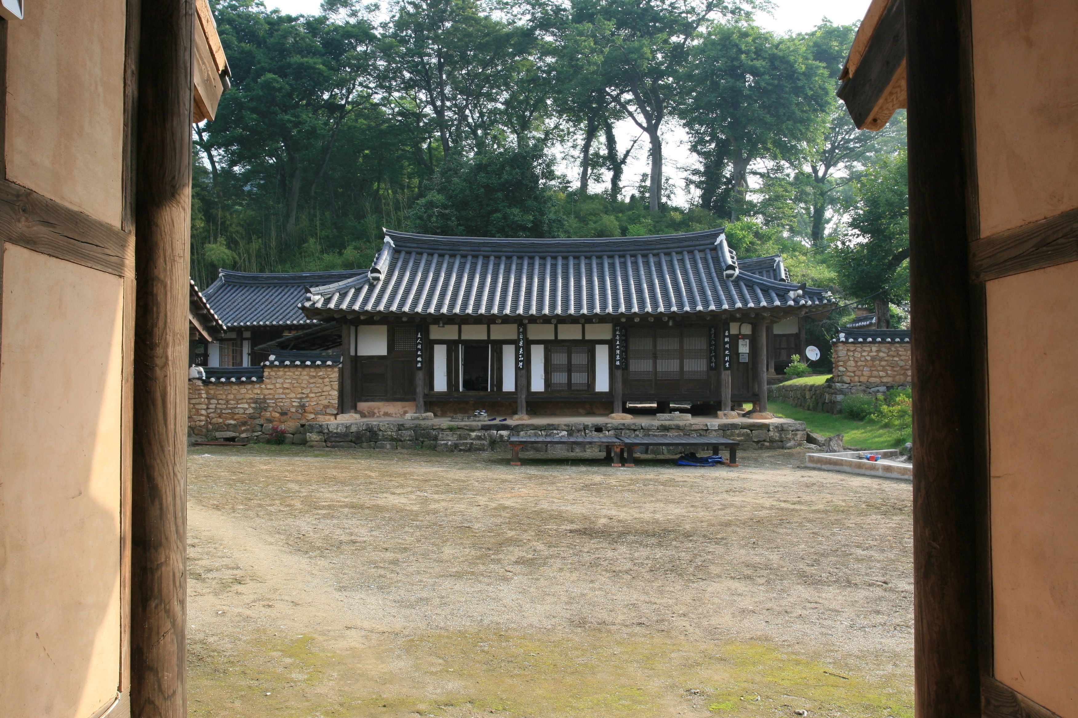 A traditional Korean building with a tiled roof and wooden walls.